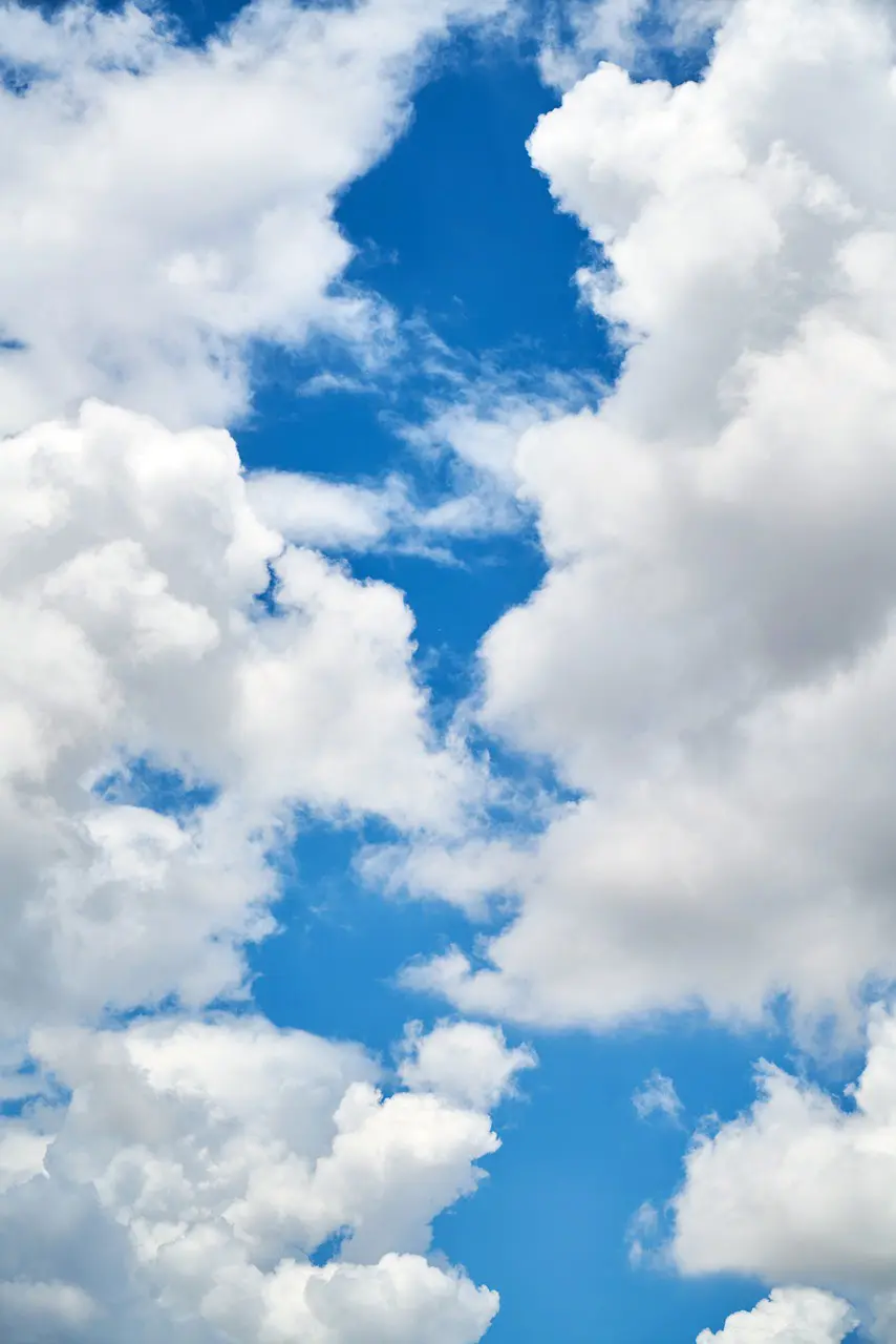 Imagem de nuvens brancas contra um céu azul, representando o verão
